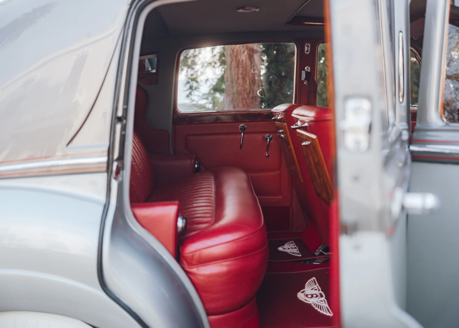 The Bentley's red leather rear seat, wooden trim and fold-down tables